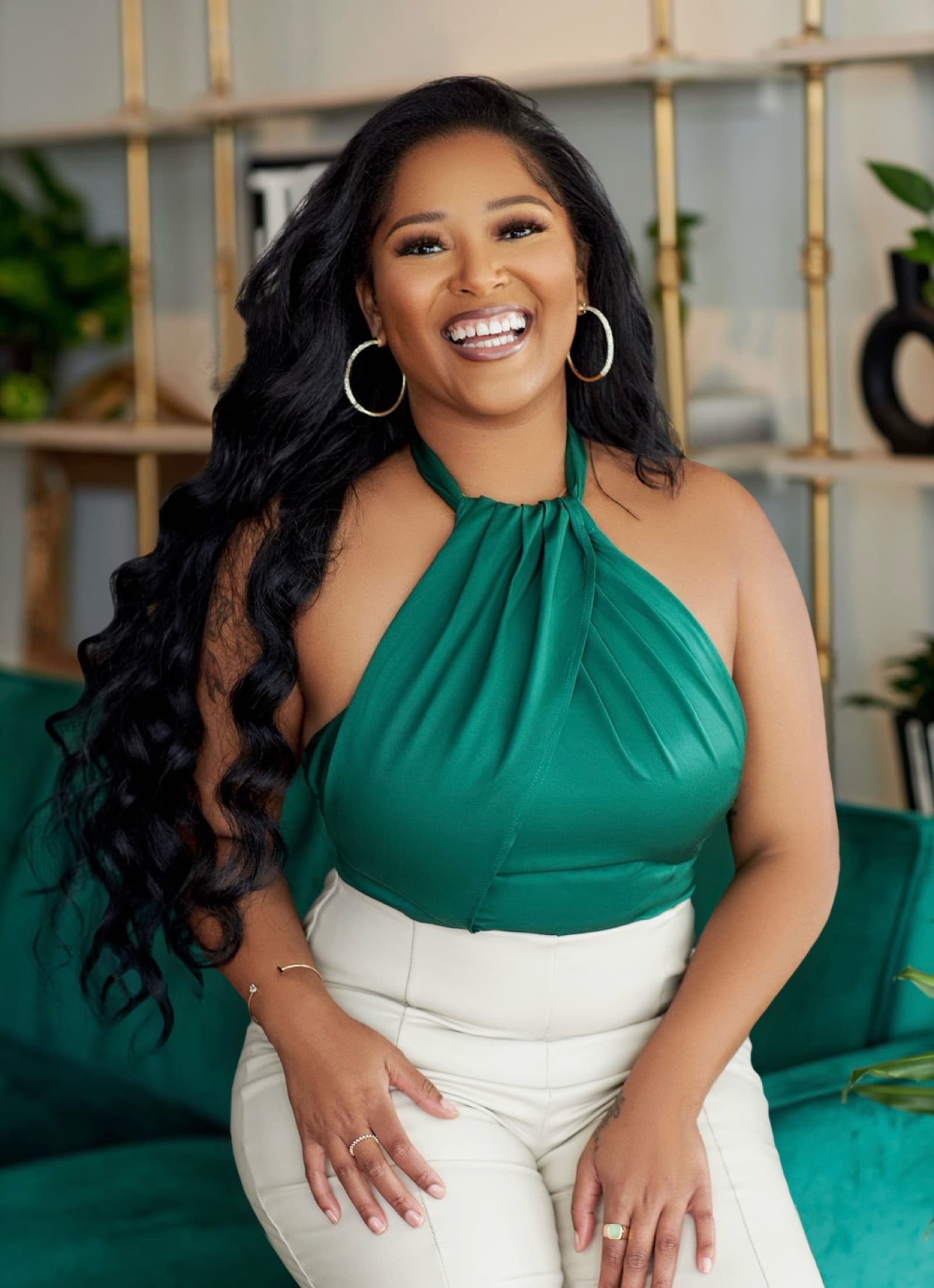 Porschia Wimbush laughing in a warm, plant-filled interior
